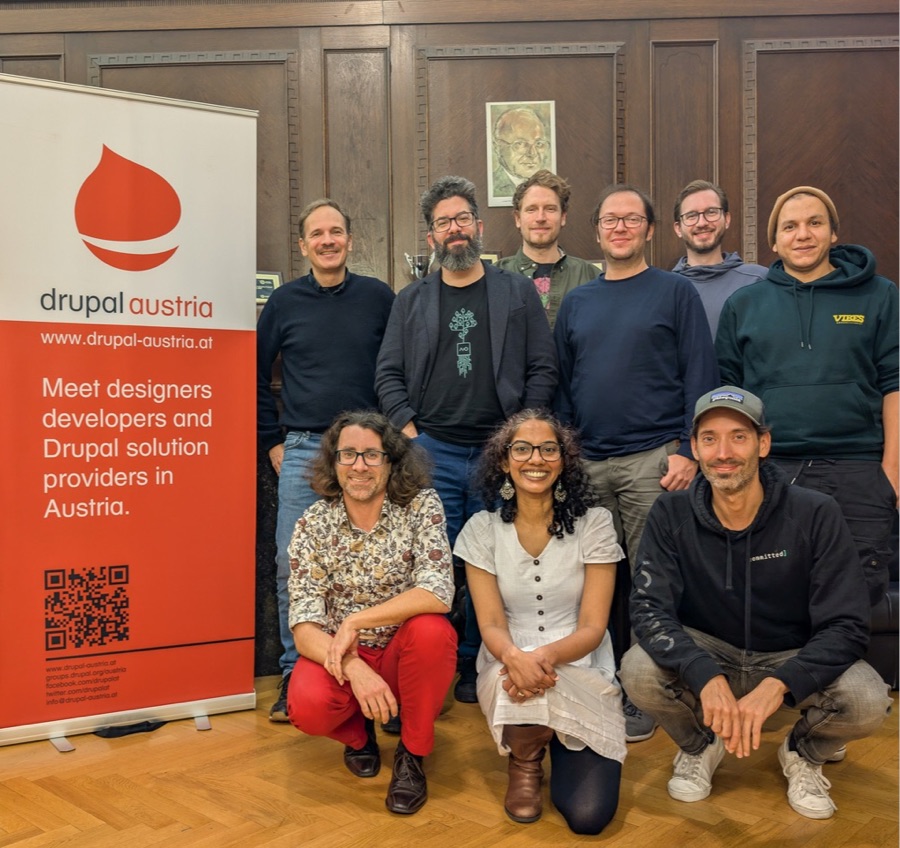 Mitglieder des Vereins Drupal Austria bei der Generalversammlung 2025, vor einem Roll-up mit dem Drupal-Austria-Logo